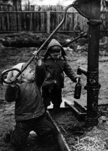 Geschwister an einer Pumpe – Brandenburg, DDR (1970er)