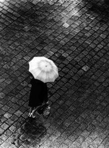 Frau mit Regenschirm auf Kopfsteinpflaster – Cottbus, Brandenburg, DDR (1965-1969)